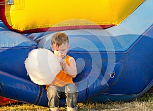 Cute small boy enjoying a stick of candy floss