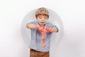 Cute small boy playing with slime looks like a red gunk