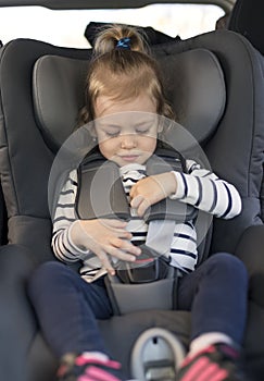 Cute small girl in car seat in the car