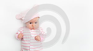 Cute small girl in a pink hat with bunny ears. Childhood concept. Light background. Happy emotion. Copyspace. Stay home