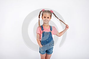 Cute small girl smailing and pulling her hair in the air,  on white background