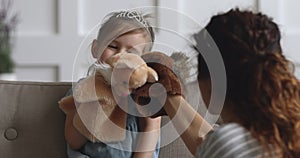 Cute small kid girl holding puppet toy playing with mother