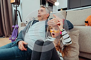 Cute small long-haired girl with eye patches and her father looking scared