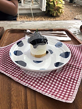 Cute small piece of homemade blueberry cheesecake on round ceramic white plate