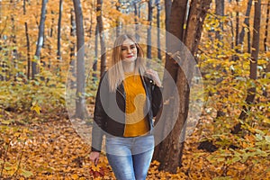 Cute smiley woman holding autumn leaves in fall park. Seasonal, lifestyle and leisure concept.