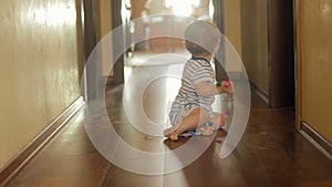 Cute smiling baby boy playing on floor with toys