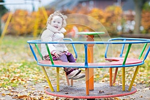 Cute smiling baby girl having fun at the playground