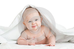 Cute smiling baby kid lying covered by bath towel