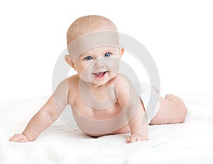 Cute smiling baby lying on white towel in nappy