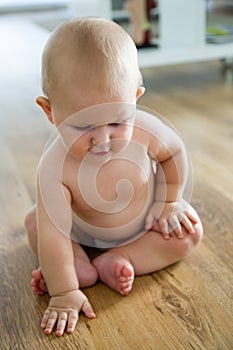 Cute smiling baby sitting at home.