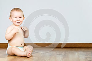 Cute smiling baby sitting at home.