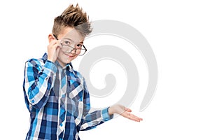 Cute smiling boy wearing reading glasses and pointing with hand to one side studio portrait on white.