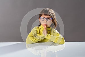 Cute smiling child enjoying thinking, praying for hope and wellbeing