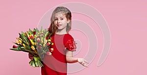 Cute smiling child girl holdi isolated on pink background. Little toddler girl gives a bouquet to mom.