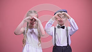 Cute smiling children making hearts with their hands, celebrating Valentines day