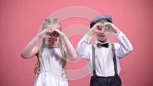 Cute smiling children making hearts with their hands, celebrating Valentines day