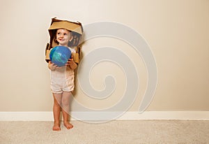 Cute smiling girl with cardboard helmet hold planet earth