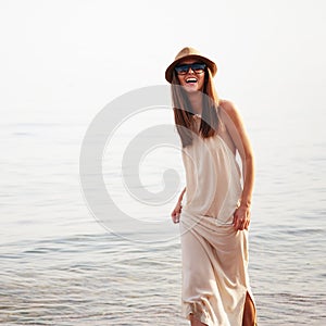 Cute smiling joyful woman spend summer holidays on a sea beach