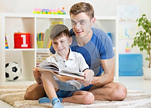 Cute smiling kid reading book in children room