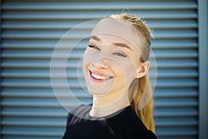 Cute smiling and laughing young blonde woman, exercising in city outdoor, lifestyle portrait.