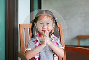 Cute smiling little Asian girl with welcome orchids flower garland