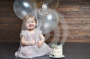 Cute smiling little girl celebrate her first birthday party with balloons and cake