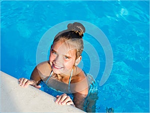 Cute smiling little girl child having fun in the swimming pool