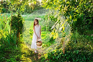 Cute smiling little girl holds basket with fruit and vegetables