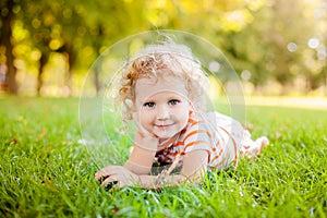 Cute smiling little girl laying on grass