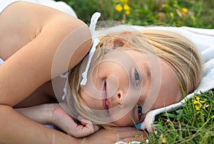 Cute smiling little girl lying on the blanket