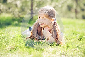 Cute smiling little girl lying on the grass