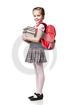 Cute smiling schoolgirl in uniform standing on photo