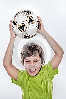 Cute Smiling Soccer Kid Holding Ball above His Head