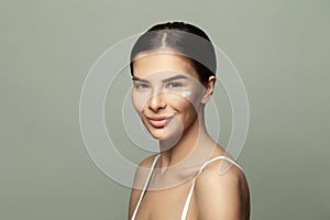 Cute smiling spa model woman with cream on her clean perfect skin. Beauty portrait close-up