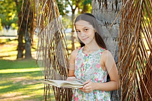 Cute smiling teen girl reading book