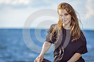 Cute Smiling Winsome Relaxing Caucasian Blond Female Girl Posing Outdoors While Sitting Outdoors At Sunny Day Near Seashore