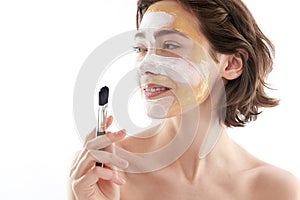 Cute smiling woman with face mask and brush