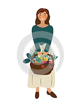 Cute smiling woman in holding basket full of vegetables. Portrait of happy adorable young girl gardener