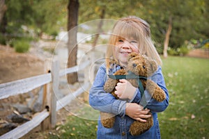 Cute Smiling Young Girl Hugging Her Teddy Bear Outside