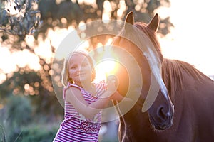 Cute smilling little girl with her handsome horse