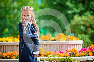 Cute smilling little girl posing in front of her school on first of September. Adorable little kid feeling very excited