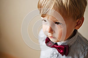 Cute solemn little boy wearing a bow tie