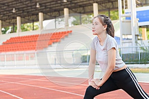 Cute sport woman stretching warm up before running on track