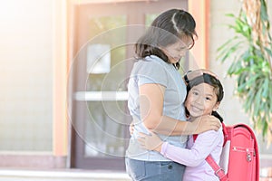 Cute student with bagschool hugging her mother