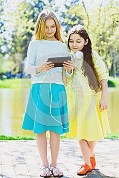 Cute stylish little girls posing at park outdoor