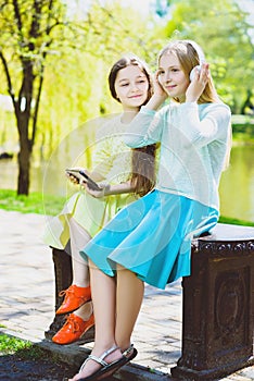 Cute stylish little girls posing at park outdoor