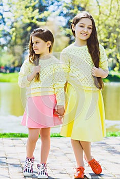 Cute stylish little girls posing at park outdoor