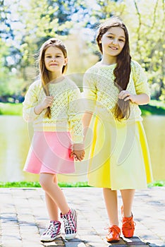 Cute stylish little girls posing at park outdoor