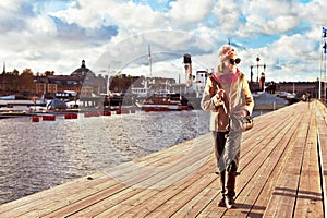 Cute stylish and trendy girl walking on pier in Stockholm. photo