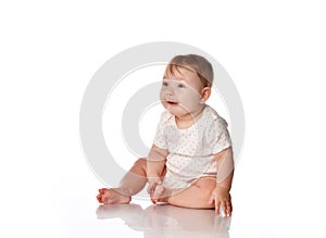 Cute surprised baby girl sitting on studio floor